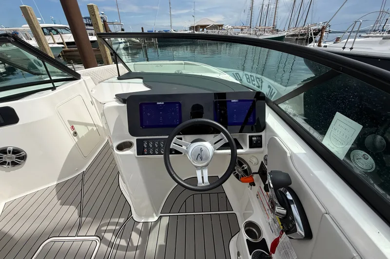 Slide: The Image of 2025 Sea Ray SDX 250 Surf boat dashboard with steering wheel and control panel. - 10