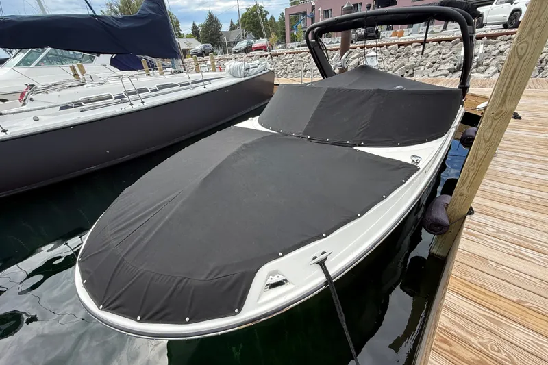 Slide: The Image of 2025 Sea Ray SDX 250 Surf boat docked, covered with black canvas. - 18