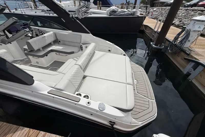 Slide: The Image of 2025 Sea Ray SDX 250 Surf boat with luxurious seating at a dock. - 4