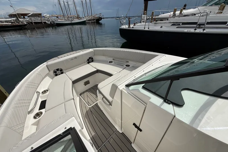 Slide: The Image of 2025 Sea Ray SDX 250 Surf boat interior with luxurious seating at a marina. - 12