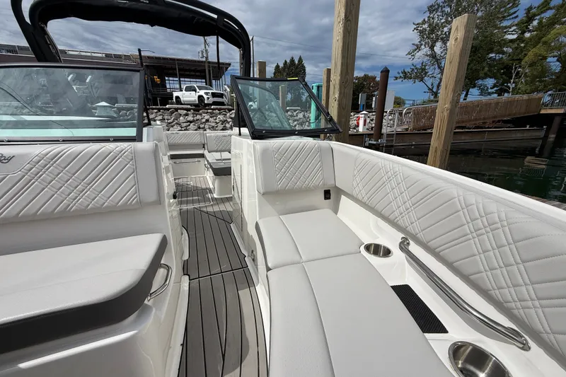 Slide: The Image of 2025 Sea Ray SDX 250 Surf boat interior with luxurious white seating and sleek design. - 14