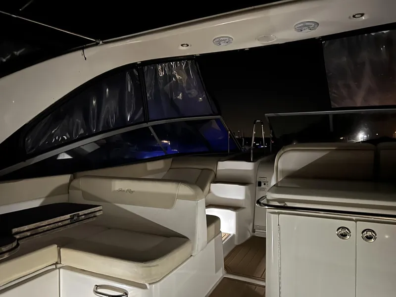 Slide: The Image of Interior of 2013 Sea Ray 370 Venture yacht at night, featuring seating and cabinetry. - 8