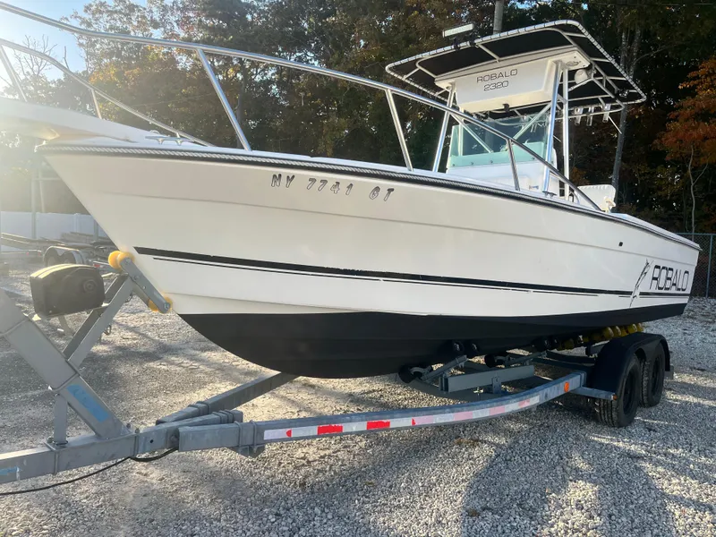 Slide: The Image of 1994 Robalo 23 boat with Merc Optimax 225 outboard on trailer, parked outdoors. - 1