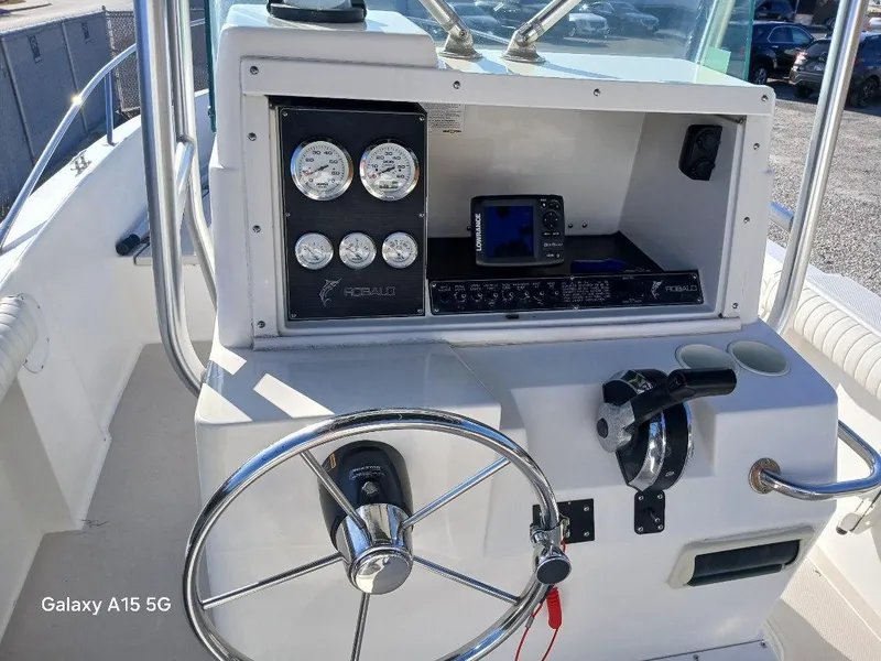 Slide: The Image of 1994 Robalo 23 boat dashboard with steering wheel and gauges. - 13