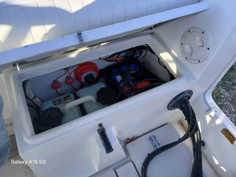 Slide: The Image of Open storage compartment of 1994 Robalo 23 boat with visible wiring and equipment. - 14