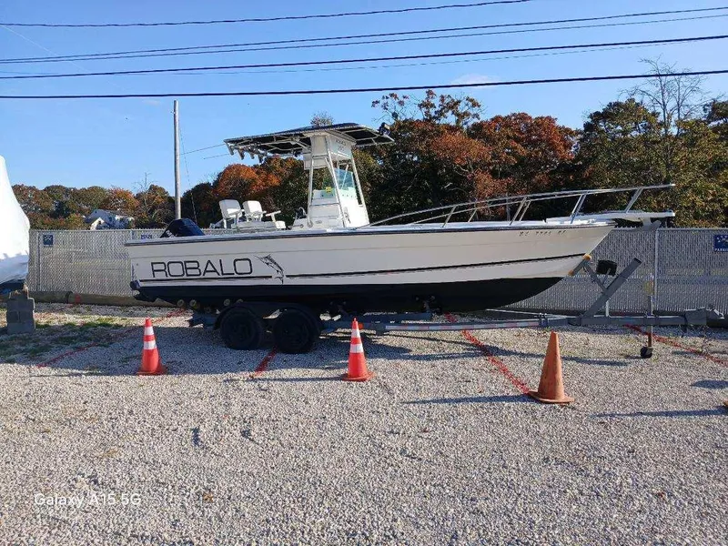 Slide: The Image of 1994 Robalo 23 boat with Merc Optimax 225 outboard on trailer, parked outdoors. - 2