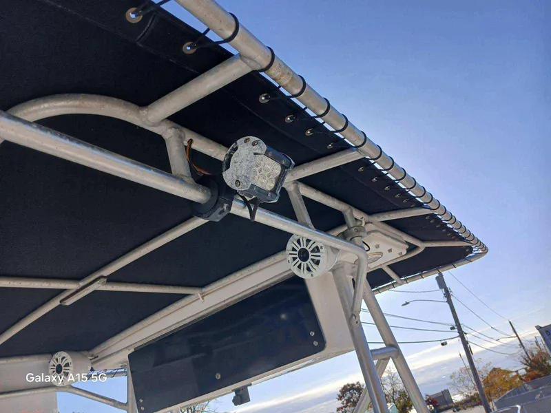 Slide: The Image of Robalo 23 boat canopy with speakers and light, 1994 model, under clear blue sky. - 21