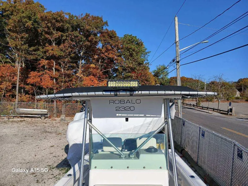 Slide: The Image of 1994 Robalo 23 boat with Merc Optimax 225 outboard, parked near autumn trees. - 26
