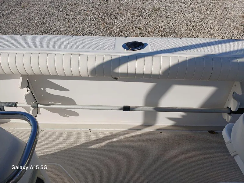 Slide: The Image of 1994 Robalo 23 boat interior with white seating and rod holder. - 29