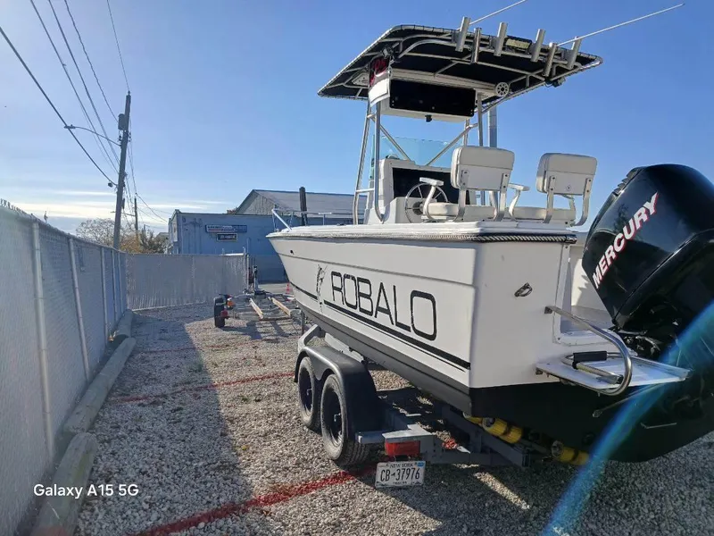 Slide: The Image of 1994 Robalo 23 boat with Mercury Optimax 225 outboard on trailer, parked outdoors. - 5