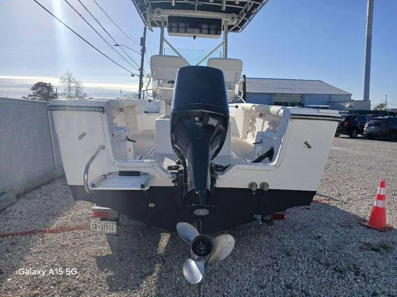 Slide: The Image of 1994 Robalo 23 boat with Merc Optimax 225 outboard engine, parked on gravel. - 6