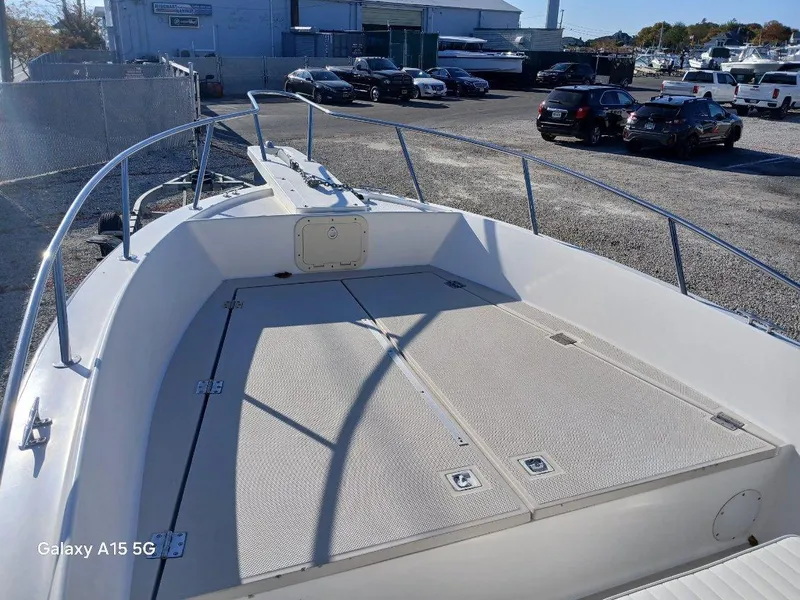 Slide: The Image of 1994 Robalo 23 boat deck with Merc Optimax outboard, parked in a marina. - 20