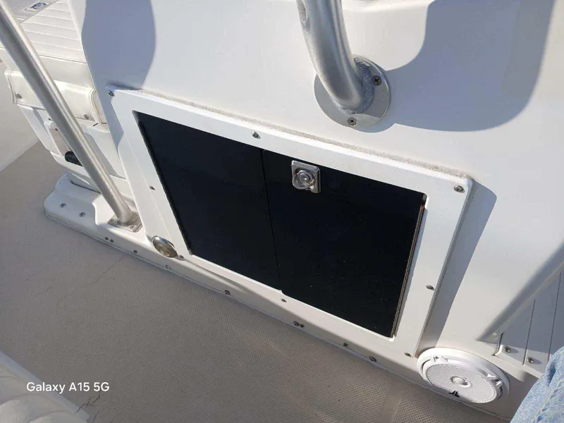 Slide: The Image of 1994 Robalo 23 boat deck with storage compartment and railing. - 30