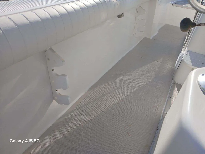 Slide: The Image of Interior view of a 1994 Robalo 23 boat, featuring white seating and flooring. - 28