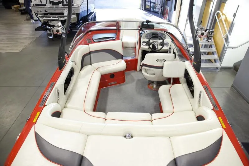 Slide: The Image of 2008 Centurion Enzo SV230 boat interior with red and white seating, steering wheel, and spacious layout. - 10