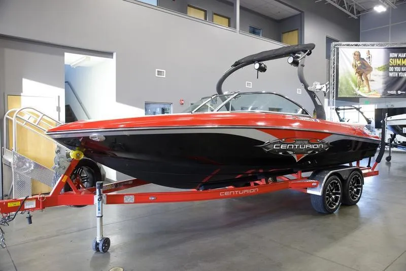 Slide: The Image of 2008 Centurion Enzo SV230 boat with red and black design on a trailer indoors. - 4