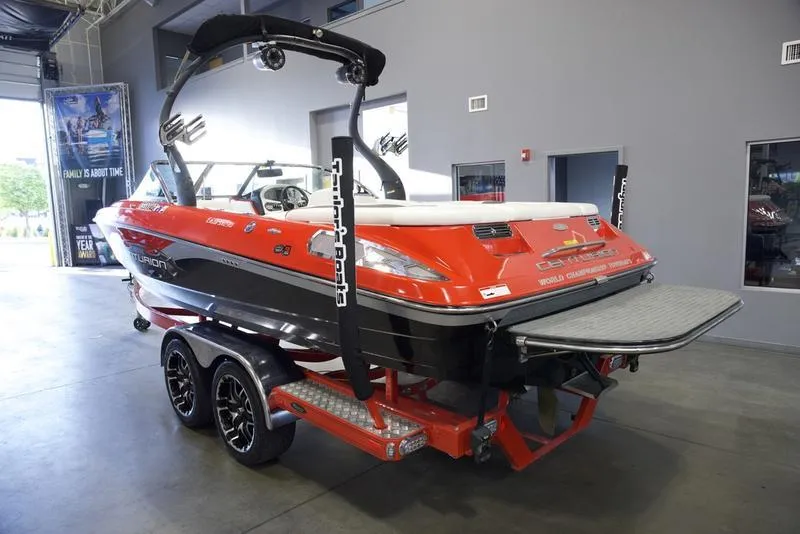 Slide: The Image of 2008 Centurion Enzo SV230 boat in showroom, red and black design, on trailer. - 7