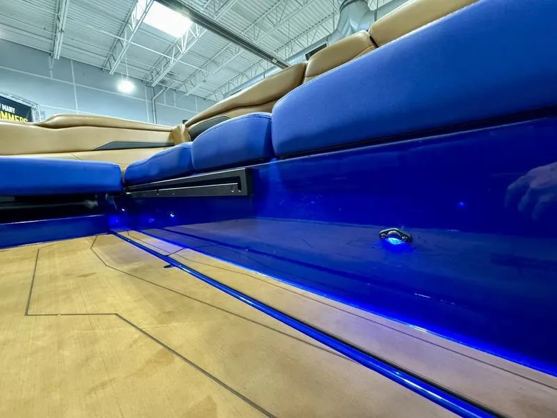 Slide: The Image of 2022 Axis T250 boat interior with blue LED lighting and tan seating. - 12