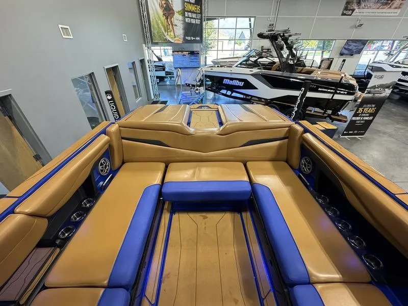 Slide: The Image of 2022 Axis T250 boat interior with tan and blue seating in showroom. - 14