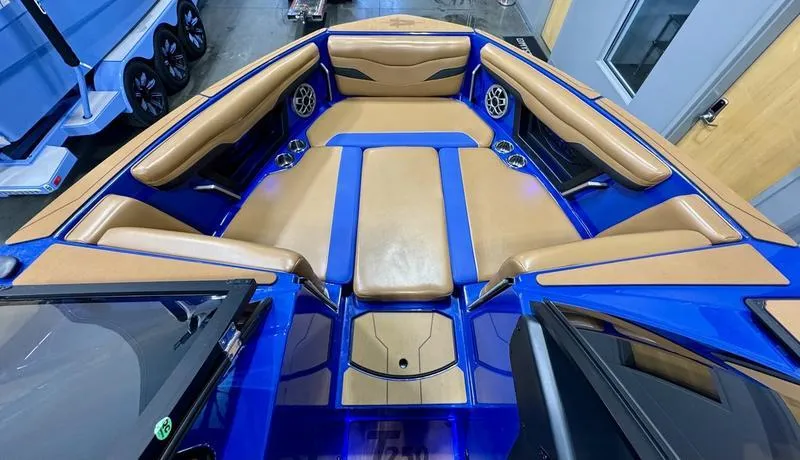 Slide: The Image of 2022 Axis T250 boat interior with tan and blue seating, featuring cup holders and speakers. - 17