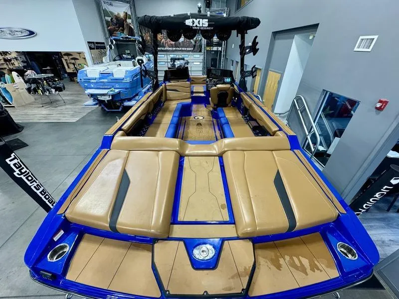 Slide: The Image of 2022 Axis T250 boat with tan and blue interior in showroom. - 7