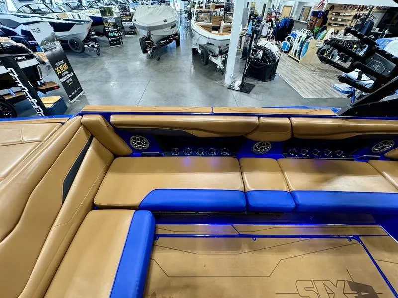 Slide: The Image of 2022 Axis T250 boat interior with tan and blue seating in showroom. - 9