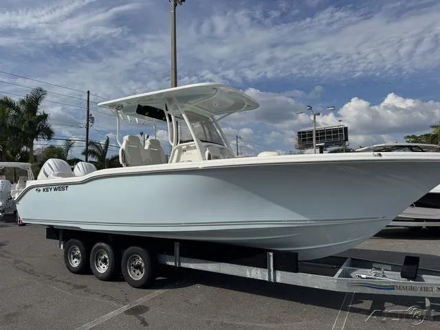 Slide: The Image of 2025 Key West 263 FS boat on trailer under cloudy sky. - 2