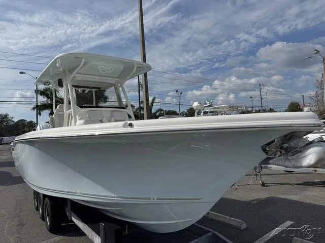 Slide: The Image of 2025 Key West 263 FS boat, front view, parked outdoors under a cloudy sky. - 3