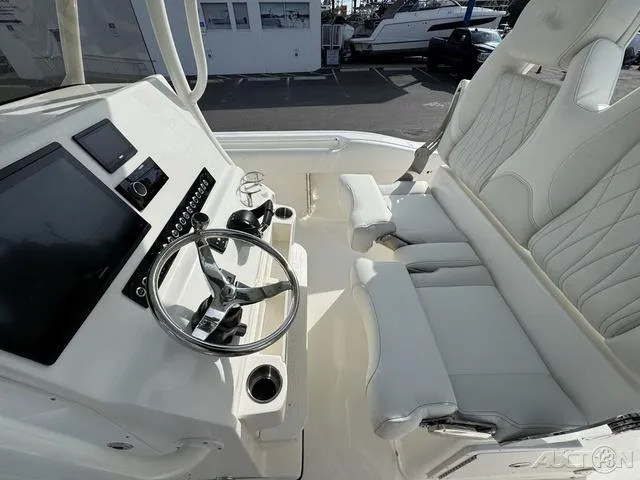 Slide: The Image of 2025 Key West 263 FS boat interior at dealership, featuring steering console and seating. - 34