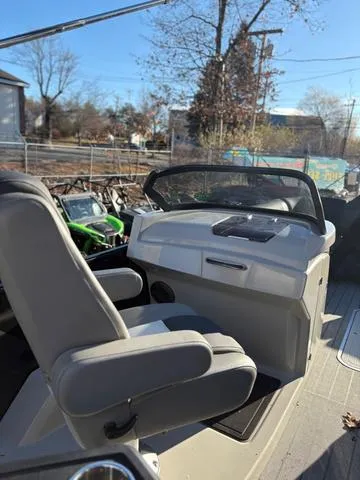 Slide: The Image of 2022 Starcraft MX 25 Q DC Tritoon interior with steering console and seating. - 12