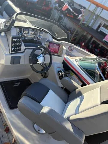 Slide: The Image of 2022 Starcraft MX 25 Q DC Tritoon boat interior with steering wheel and control panel. - 4