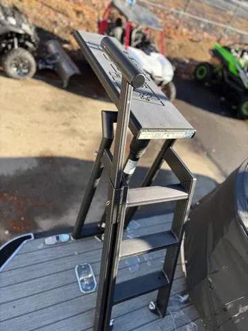 Slide: The Image of Ladder on 2022 Starcraft MX 25 Q DC Tritoon boat with trailer in background. - 8
