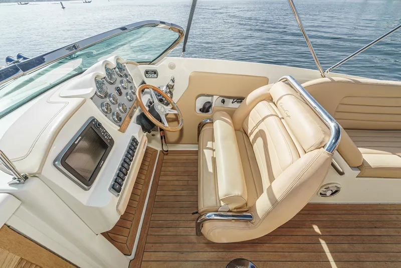 Slide: The Image of 2012 Chris-Craft Corsair 28 cockpit with luxurious seating and modern dashboard on calm waters. - 15