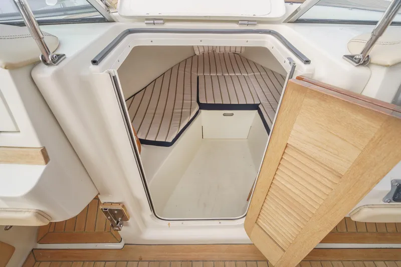 Slide: The Image of 2012 Chris-Craft Corsair 28 cabin interior with striped cushions and wooden flooring. - 23