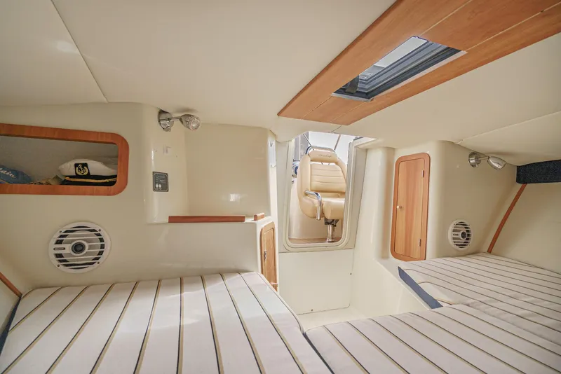 Slide: The Image of Interior of 2012 Chris-Craft Corsair 28 boat, featuring cozy cabin with seating and wood accents. - 25