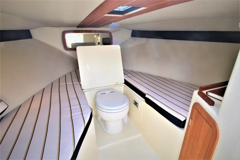 Slide: The Image of 2012 Chris-Craft Corsair 28 cabin interior with toilet and cushioned seating. - 27