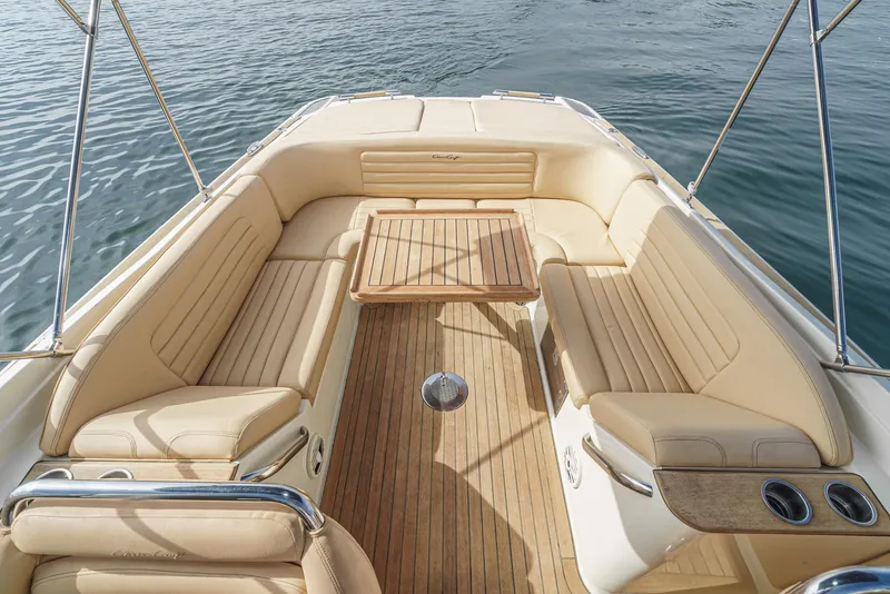 Slide: The Image of Luxurious 2012 Chris-Craft Corsair 28 boat interior with beige seating and wooden deck. - 28