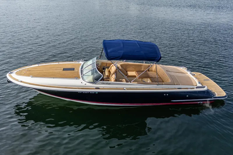 Slide: The Image of 2012 Chris-Craft Corsair 28 boat with blue canopy on calm water. - 3