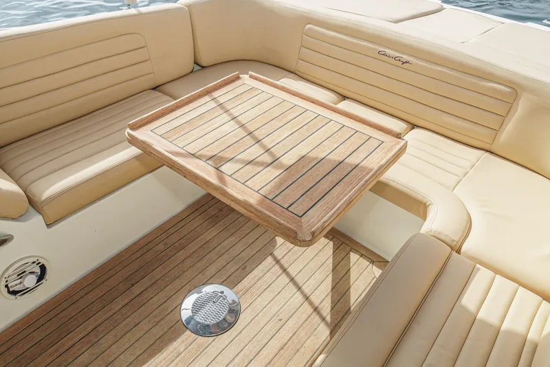 Slide: The Image of Luxurious 2012 Chris-Craft Corsair 28 boat interior with wooden table and beige seating. - 30
