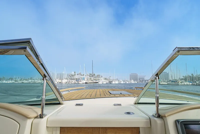 Slide: The Image of 2012 Chris-Craft Corsair 28 boat with open windshield, overlooking marina and blue sky. - 33