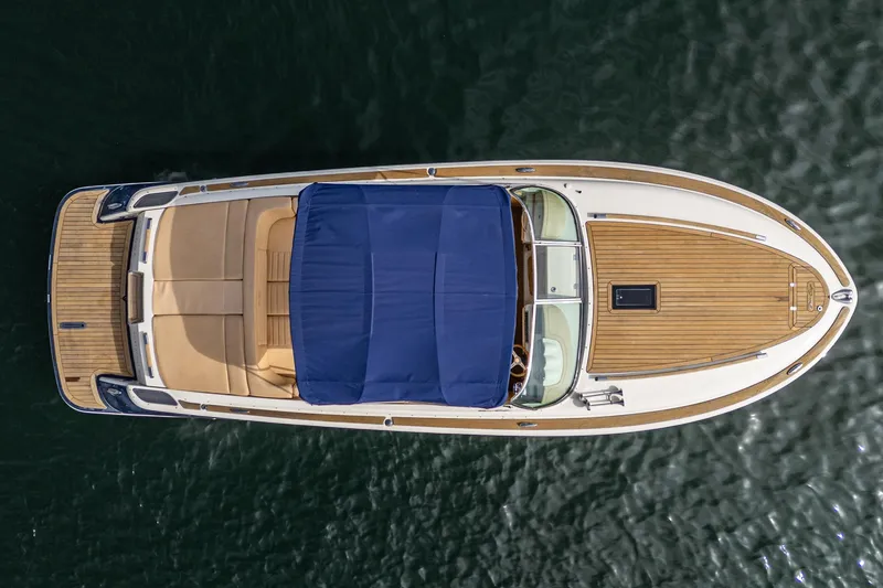 Slide: The Image of 2012 Chris-Craft Corsair 28 boat, aerial view, blue canopy, wooden deck, on water. - 5