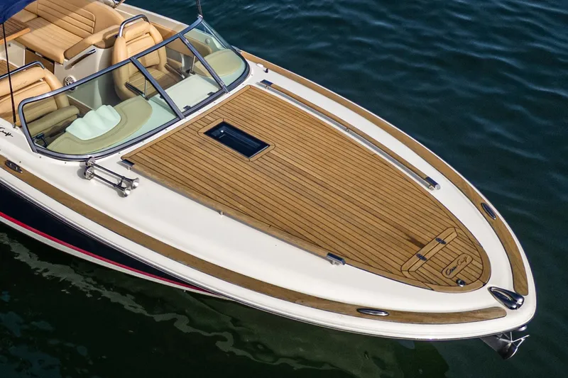 Slide: The Image of 2012 Chris-Craft Corsair 28 boat with teak deck, cruising on water. - 7