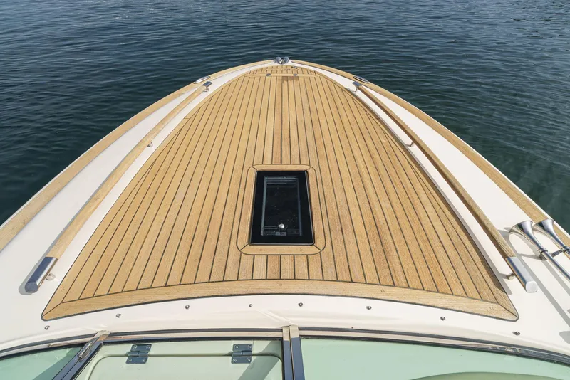 Slide: The Image of 2012 Chris-Craft Corsair 28 boat deck with teak wood finish on calm water. - 8