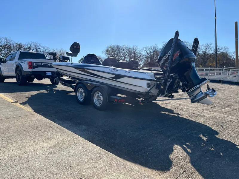 Slide: The Image of 2013 Triton 21 HP boat on trailer, parked beside a Ford truck. - 12