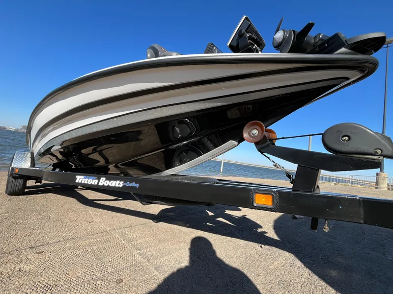 Slide: The Image of 2013 Triton 21 HP boat on trailer by waterfront. - 26