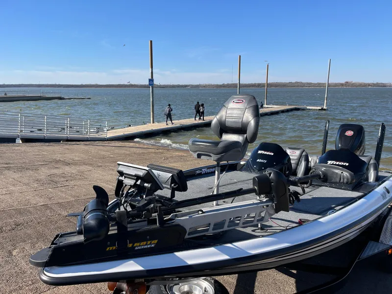 Slide: The Image of 2013 Triton 21 HP boat at lakeside dock under clear blue sky. - 3