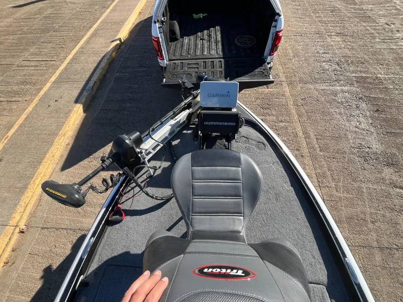 Slide: The Image of 2013 Triton 21 HP boat with Garmin equipment, parked near a truck. - 30