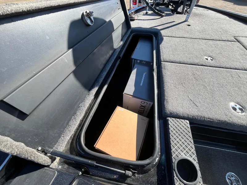Slide: The Image of 2013 Triton 21 HP boat storage compartment with boxes inside. - 32