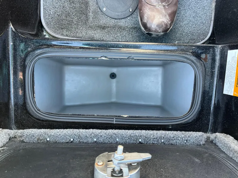 Slide: The Image of 2013 Triton 21 HP boat storage compartment with carpeted interior and latch. - 33