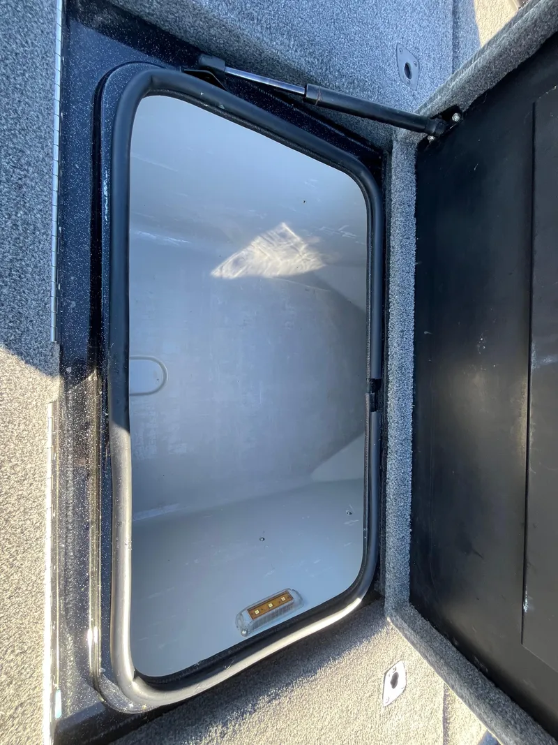 Slide: The Image of 2013 Triton 21 HP boat storage compartment with open lid. - 35